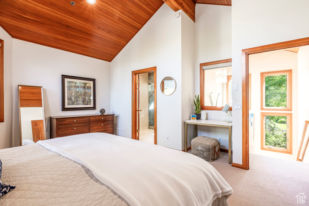Bedroom with wood ceiling, carpet floors, high vaulted ceiling, and ensuite bathroom