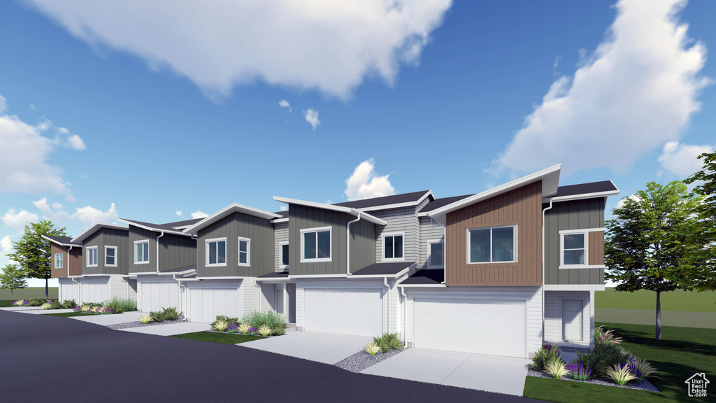 Townhome / multi-family property with a garage, driveway, and a residential view