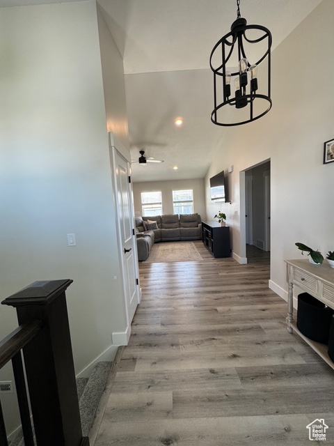 Hall featuring recessed lighting, wood finished floors, and a chandelier