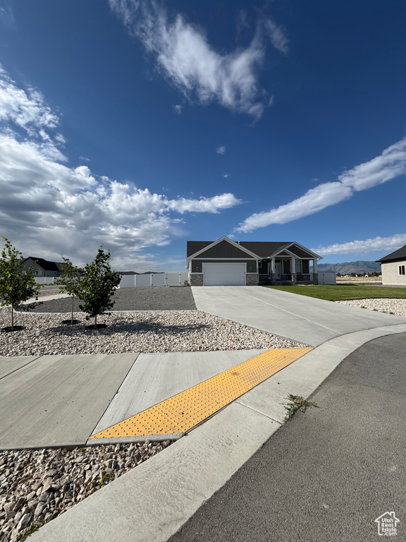 View of front of property featuring concrete driveway and an attached garage