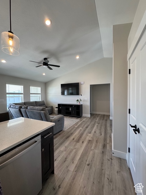 Kitchen featuring dishwasher, vaulted ceiling, ceiling fan, light wood-style flooring, and light countertops
