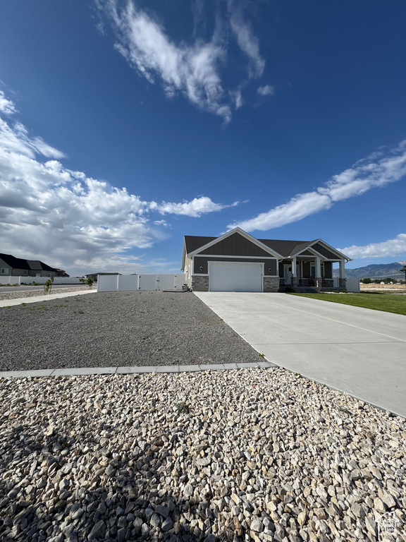 View of side of property with a garage, driveway, and stone siding