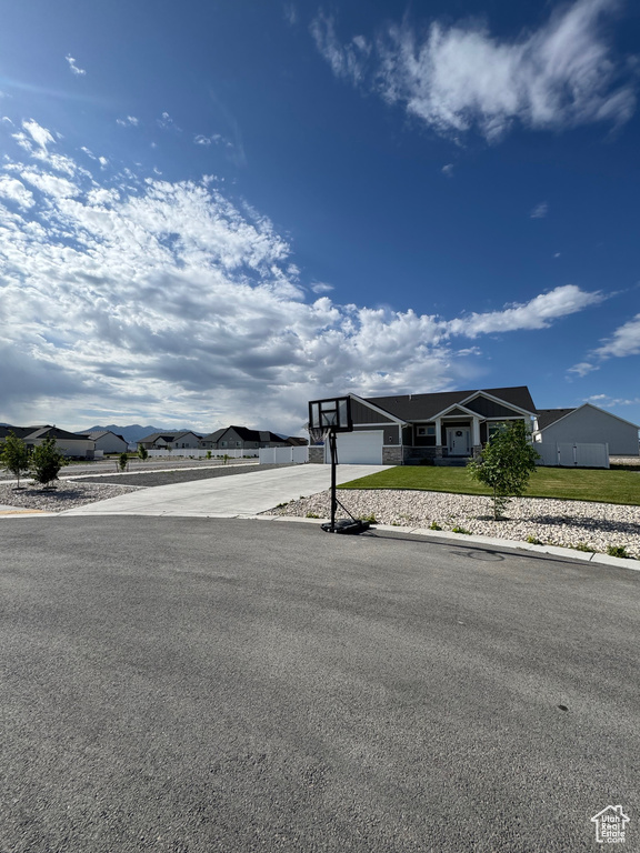 View of front of home featuring driveway, an attached garage, and a residential view