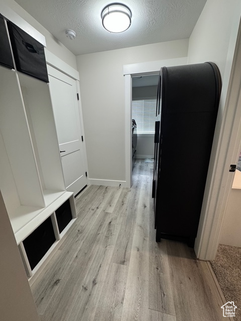 Mudroom featuring light wood-style floors and a textured ceiling