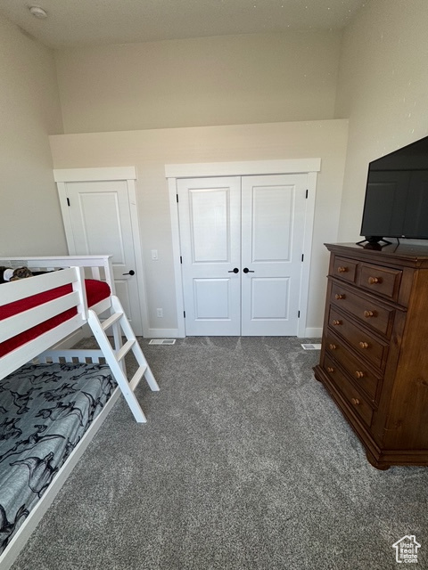Carpeted bedroom featuring a closet and baseboards