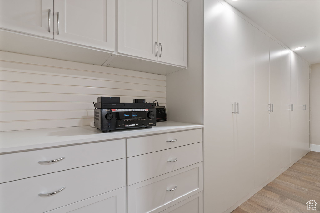 Kitchen featuring light wood-type flooring, white cabinetry, and light countertops