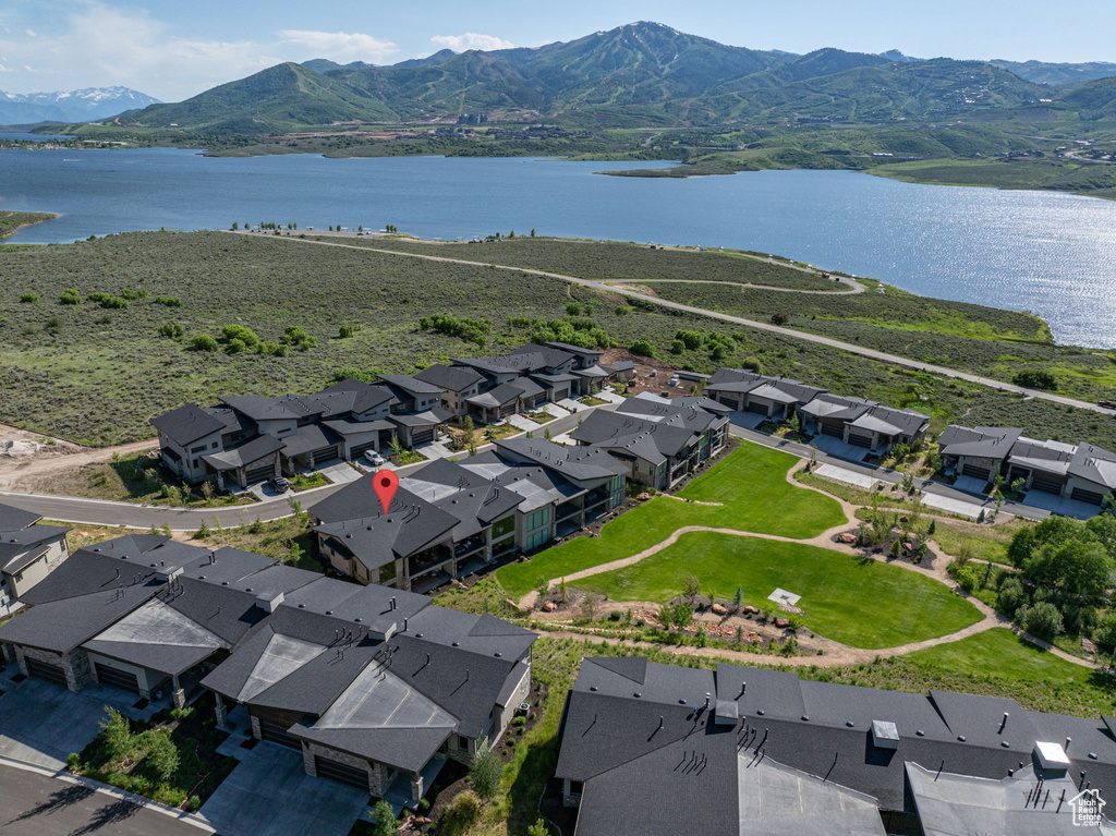 Aerial view of property and surrounding area featuring nearby suburban area and a water and mountain view