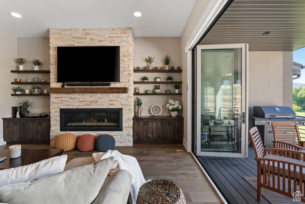 Living room with wood finished floors, a fireplace, and recessed lighting