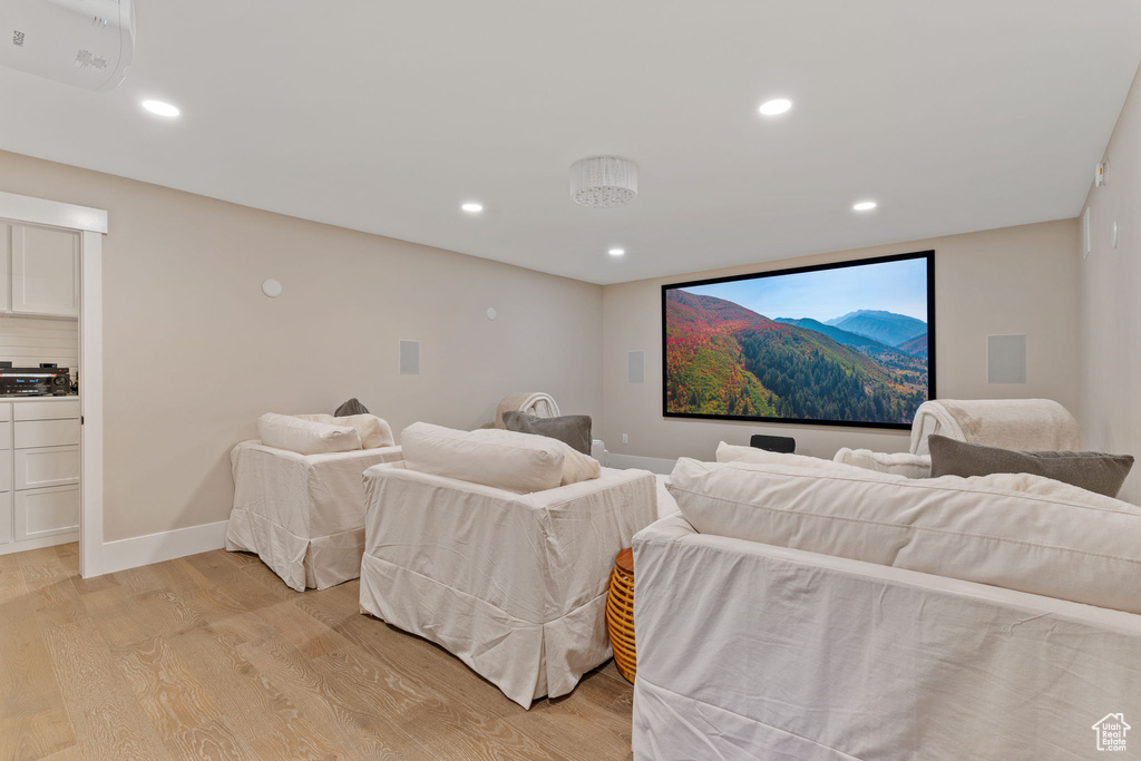Cinema room featuring light wood finished floors and recessed lighting