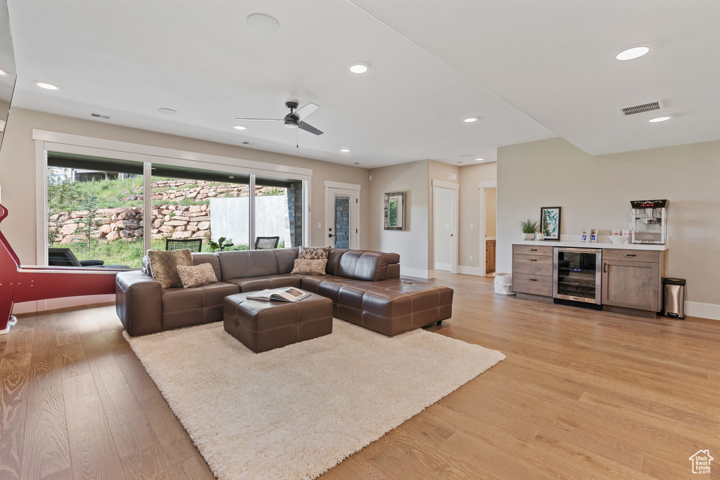 Living room featuring beverage cooler, light wood-style flooring, healthy amount of natural light, ceiling fan, and recessed lighting