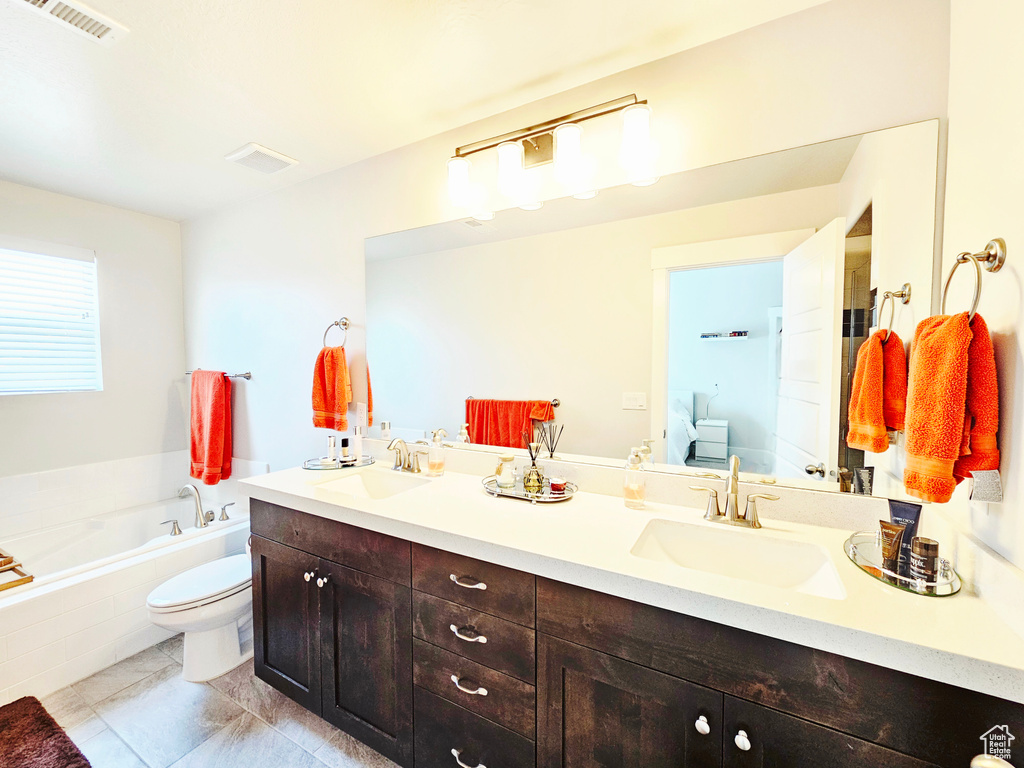 Bathroom featuring double vanity, a garden tub, and marble look tile flooring
