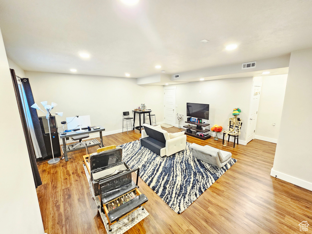Living room with recessed lighting, wood finished floors, and an office area