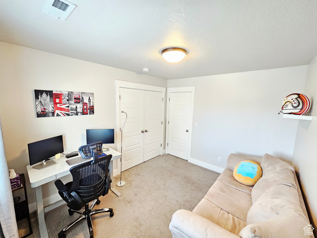 Carpeted home office featuring baseboards