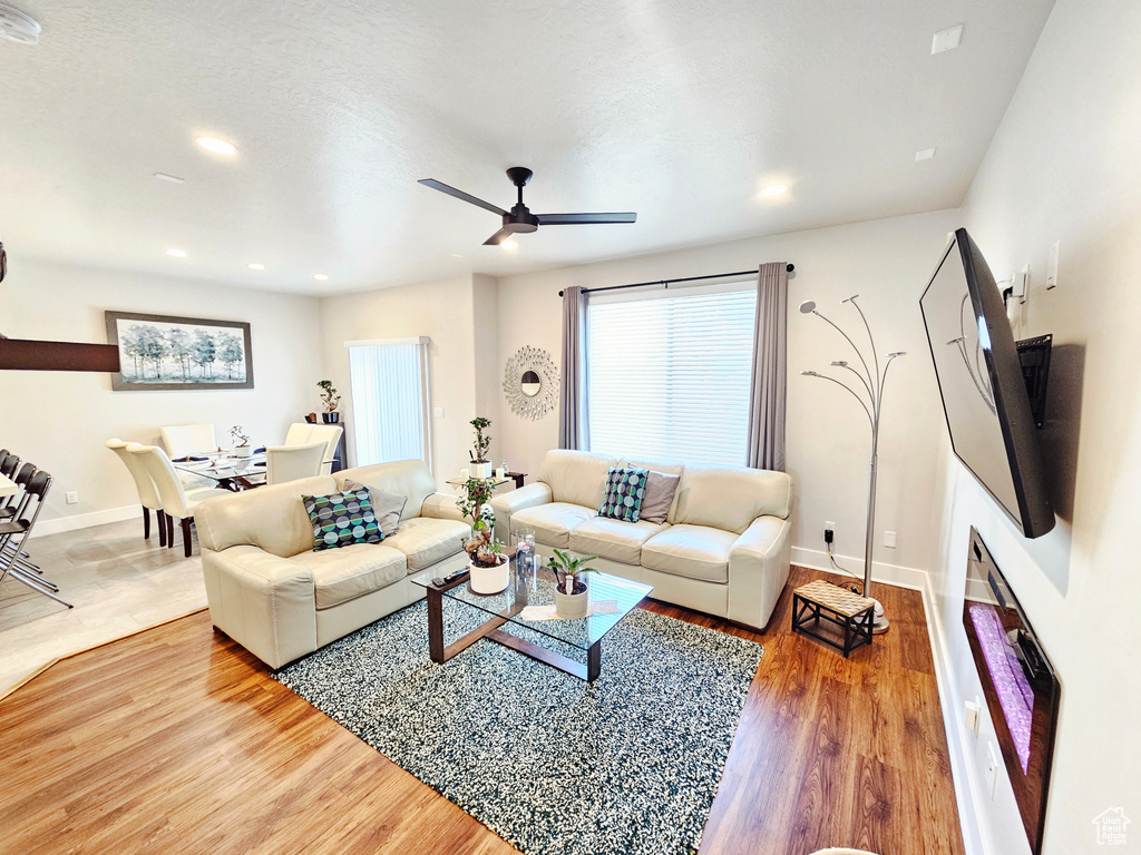Living room with ceiling fan, wood finished floors, and recessed lighting