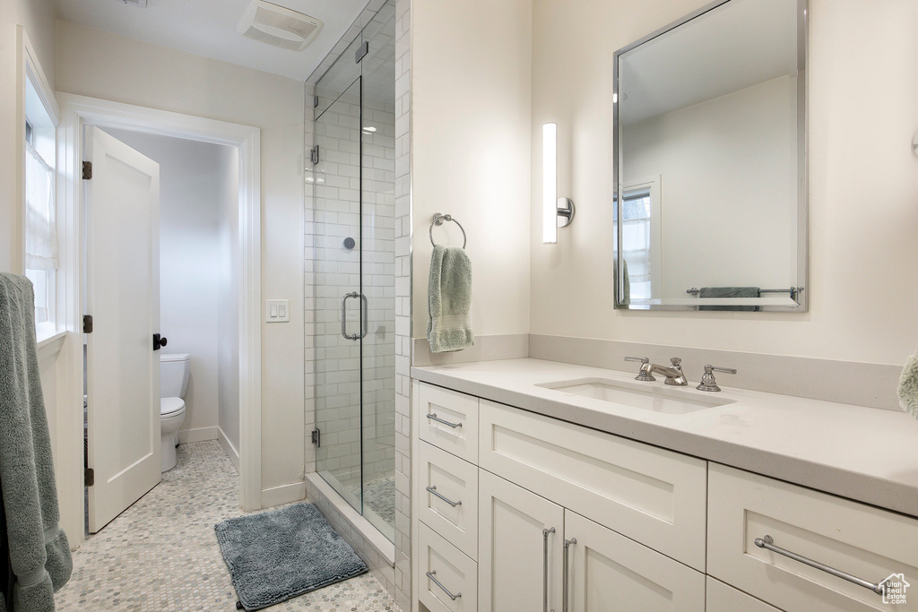Bathroom featuring vanity, a stall shower, and healthy amount of natural light