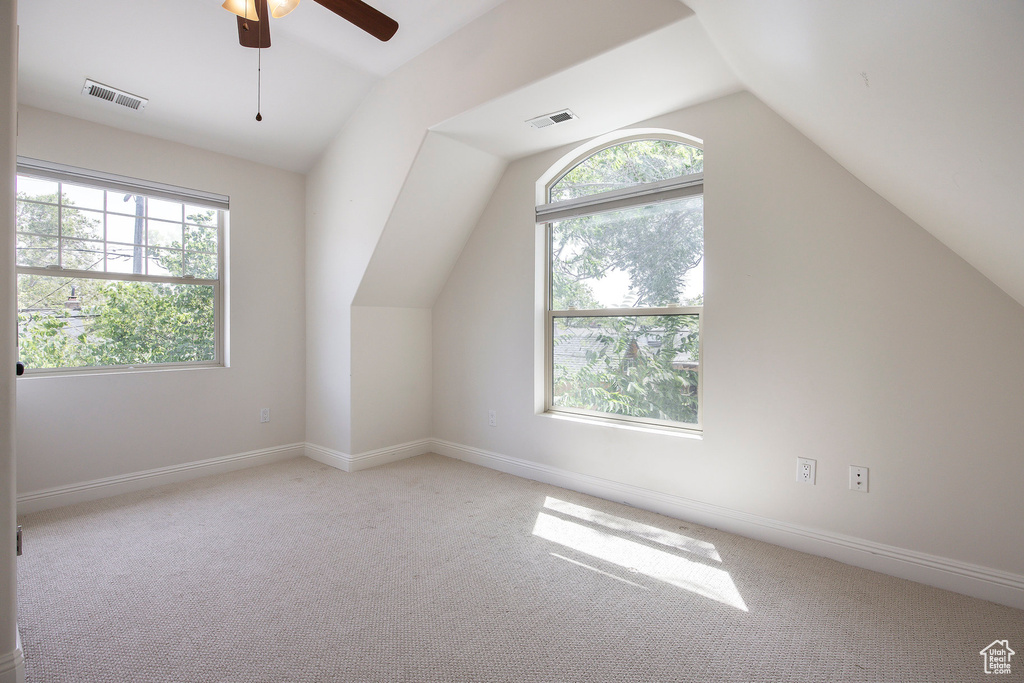 Additional living space featuring lofted ceiling, a ceiling fan, and carpet flooring