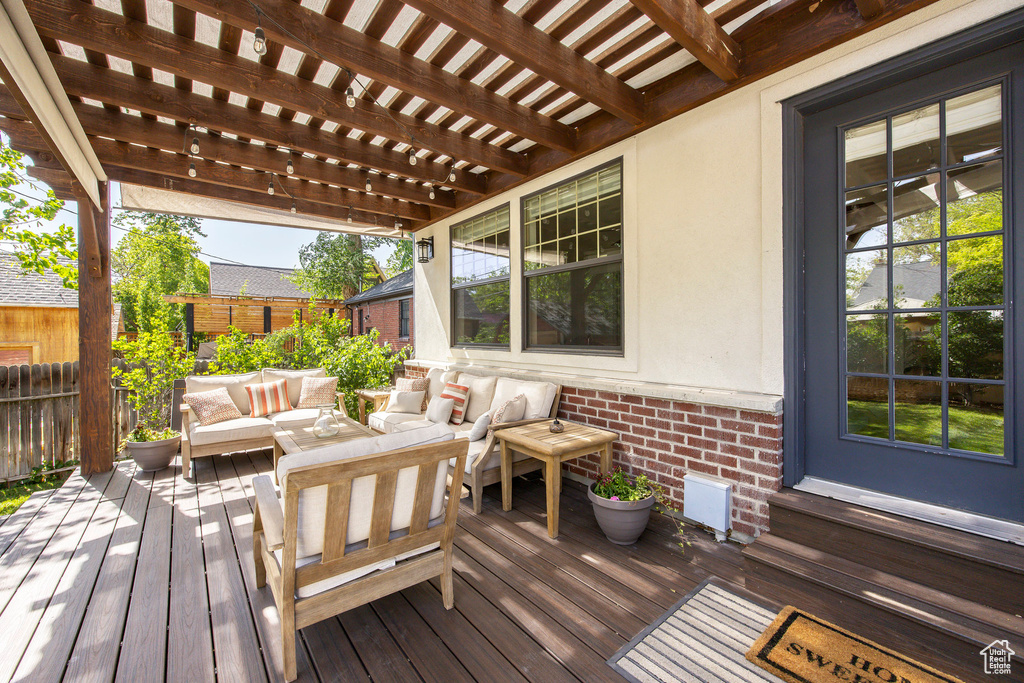Wooden deck featuring an outdoor living space and a pergola