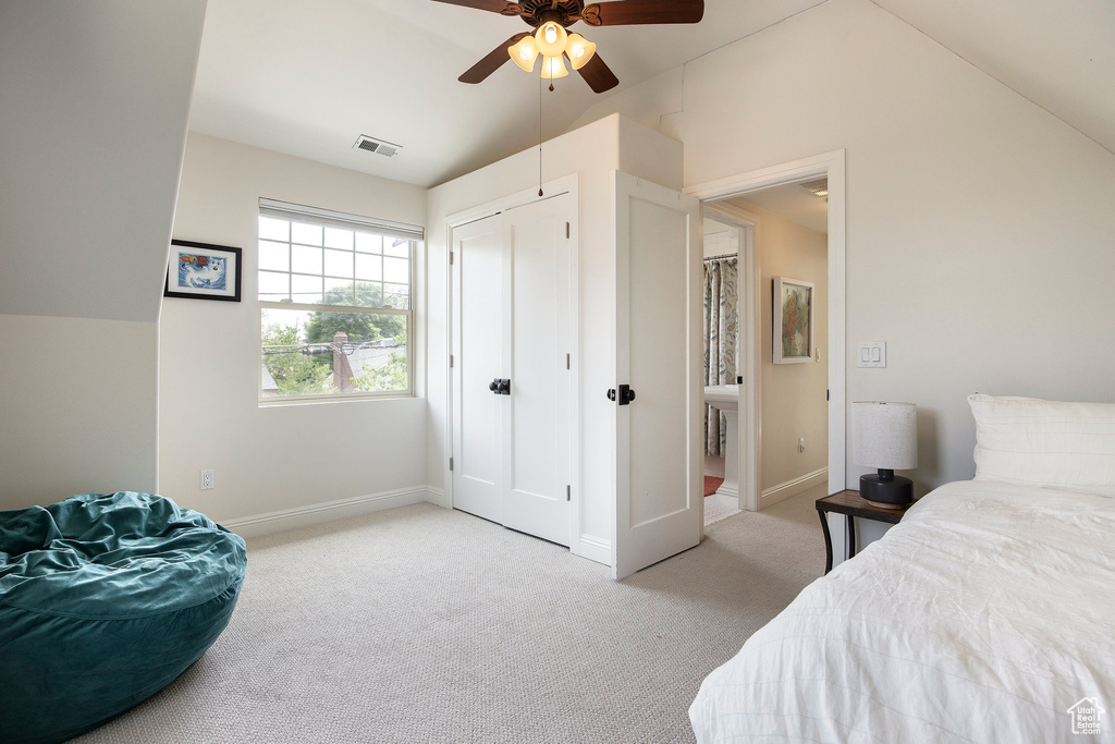Bedroom featuring light colored carpet, lofted ceiling, a ceiling fan, and a closet