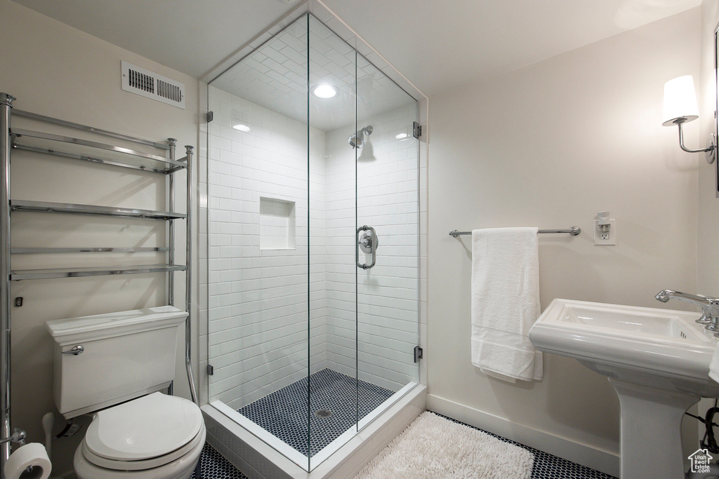 Bathroom with a stall shower and tile patterned flooring