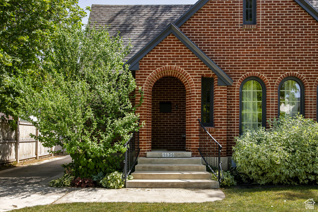 View of front of home with brick siding and roof with shingles