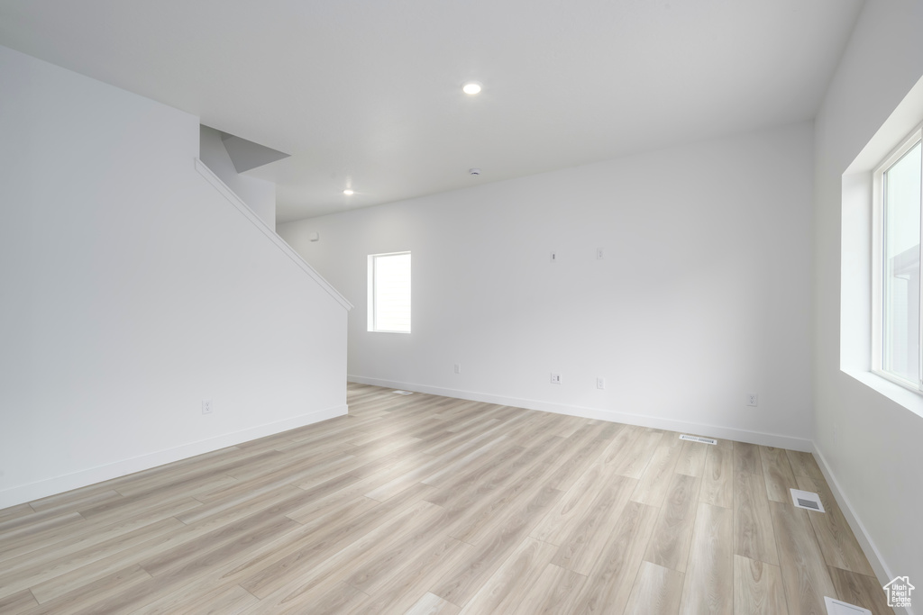 Spare room with light wood finished floors, plenty of natural light, and recessed lighting