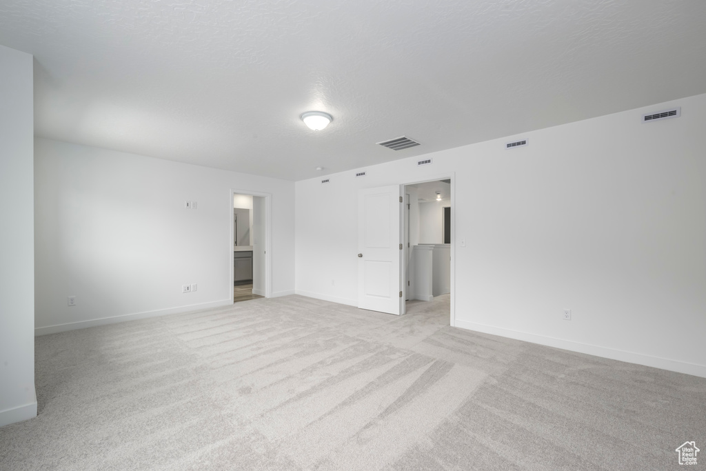 Empty room with light carpet and baseboards
