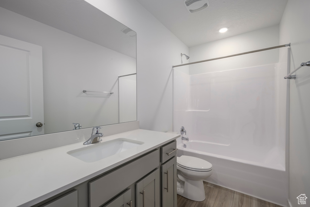 Bathroom featuring vanity, bathing tub / shower combination, and wood finished floors