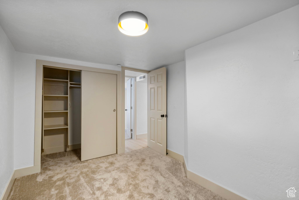 Unfurnished bedroom featuring a closet and carpet floors