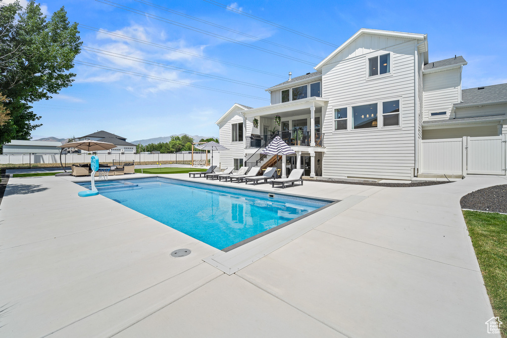 View of pool featuring a patio, a fenced backyard, and a gate