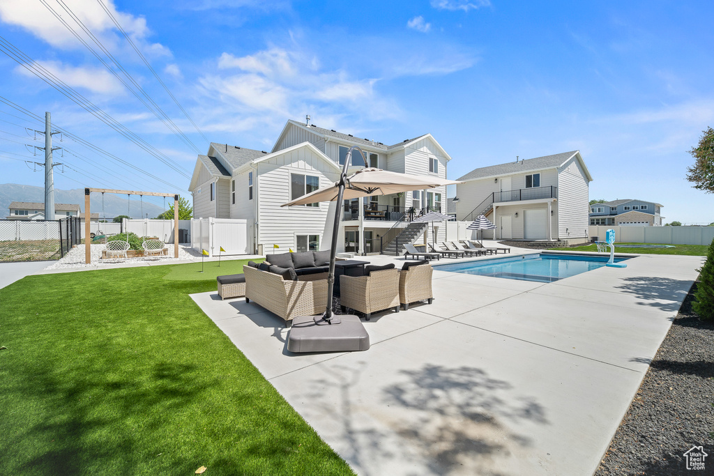 Back of house with stairway, an outdoor hangout area, a patio area, a fenced backyard, and board and batten siding