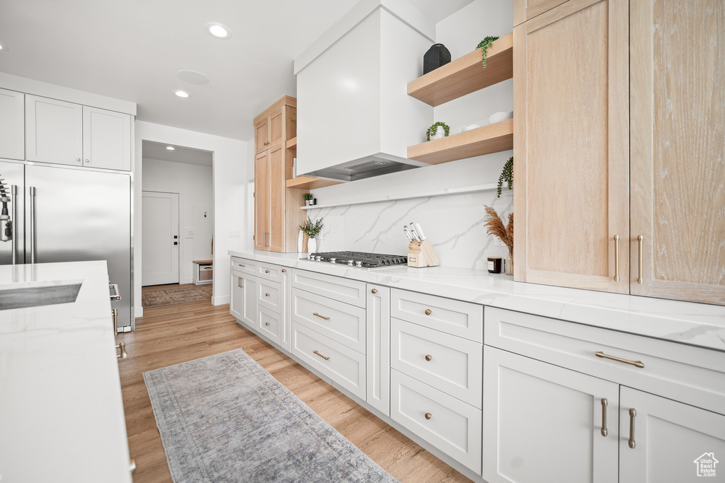 Kitchen featuring open shelves, stainless steel appliances, backsplash, light stone countertops, and recessed lighting