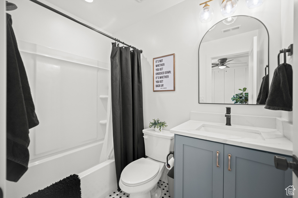 Full bathroom with vanity, shower / bath combo with shower curtain, and a ceiling fan