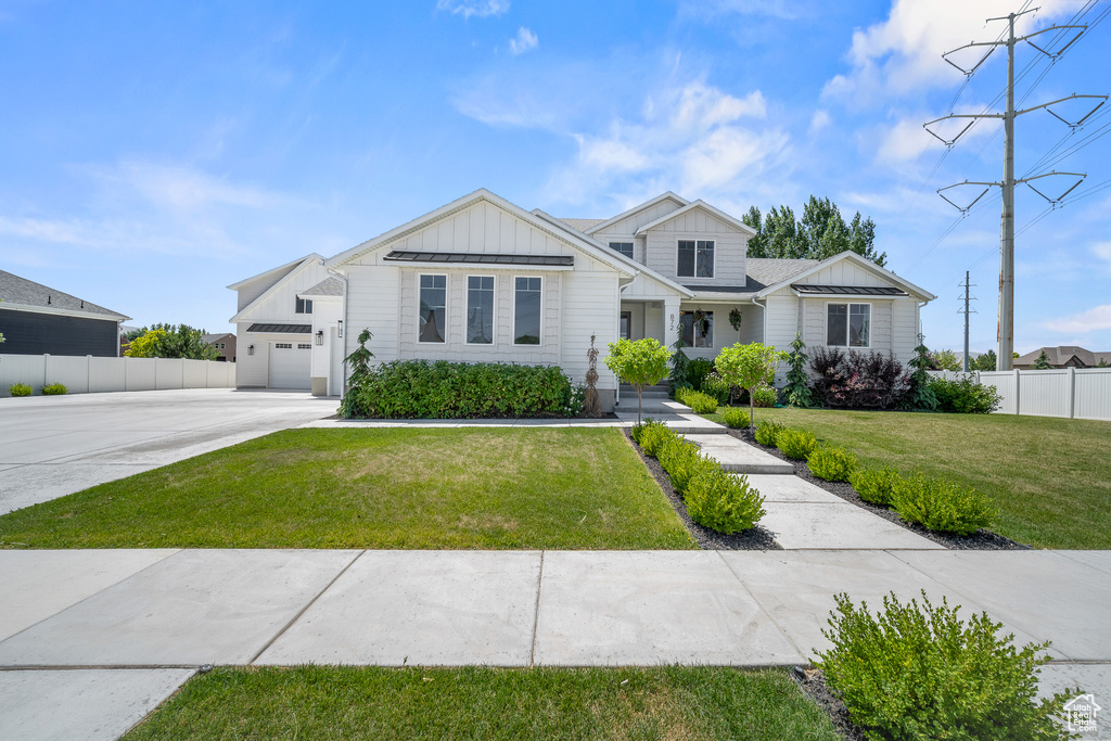 View of front of property with board and batten siding, concrete driveway, and an attached garage