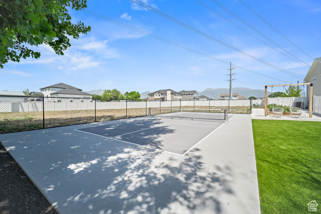 View of sport court with a tennis court and a mountain view