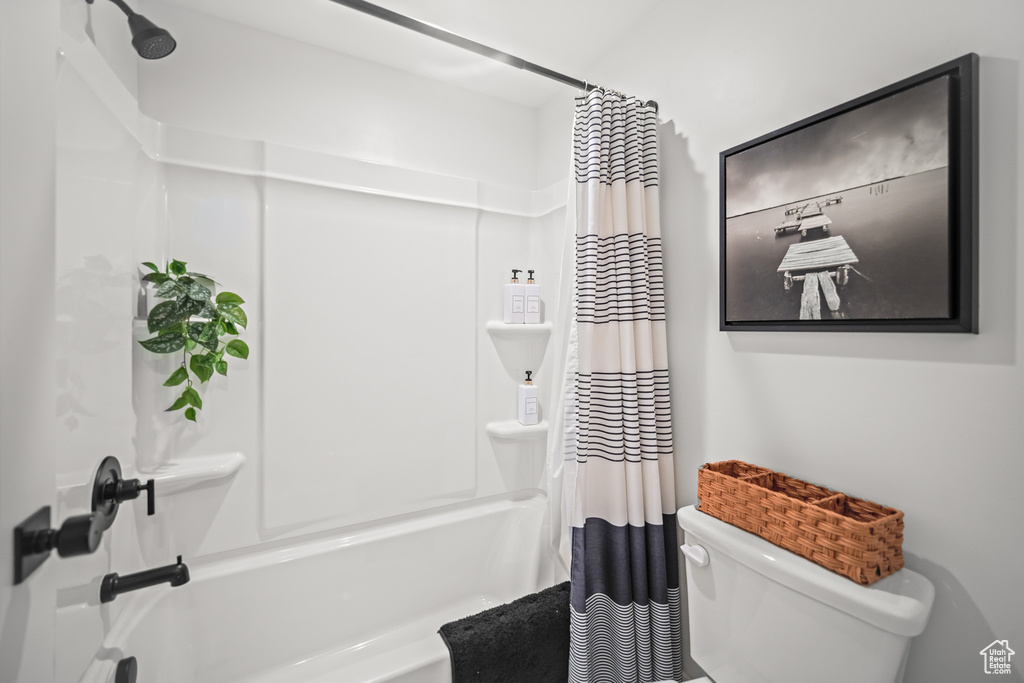 Bathroom featuring shower / tub combo with curtain and toilet