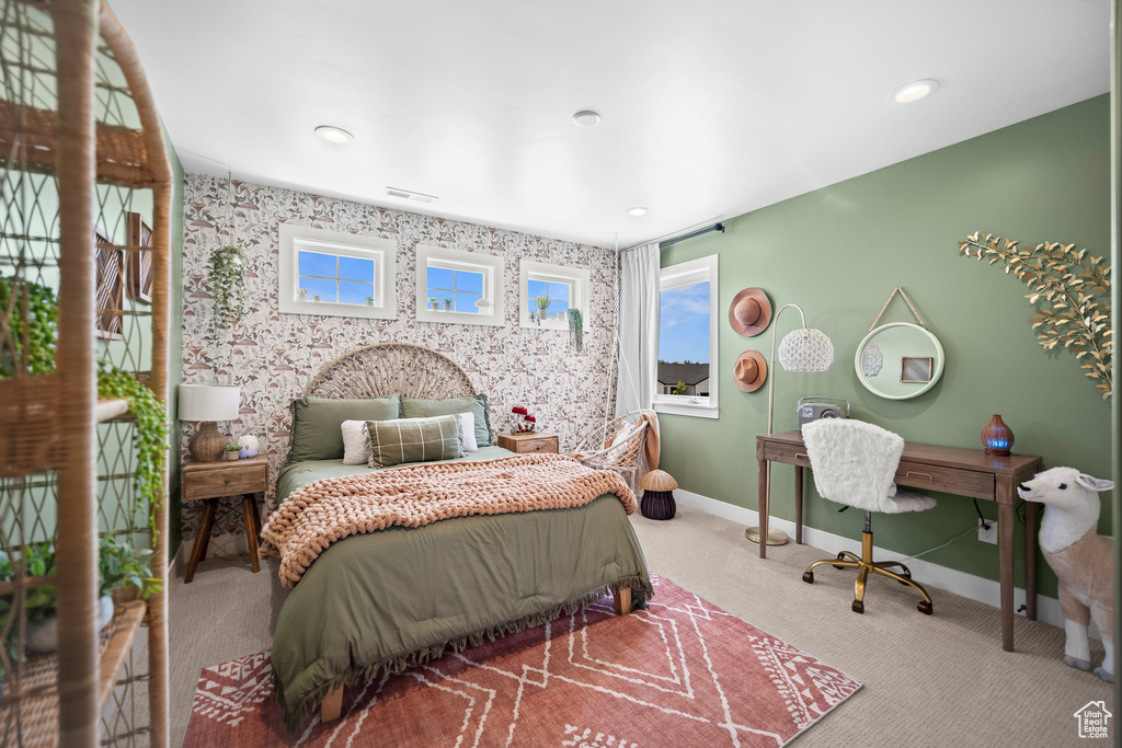 Carpeted bedroom with multiple windows, wallpapered walls, and recessed lighting