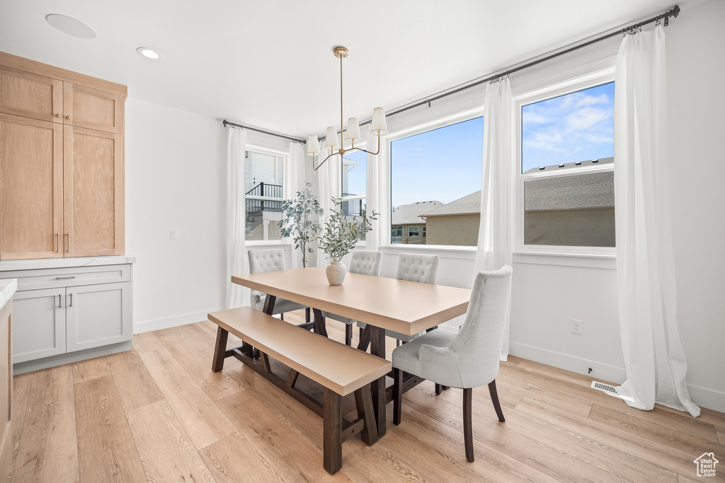 Dining space featuring light wood-style floors, recessed lighting, and a chandelier