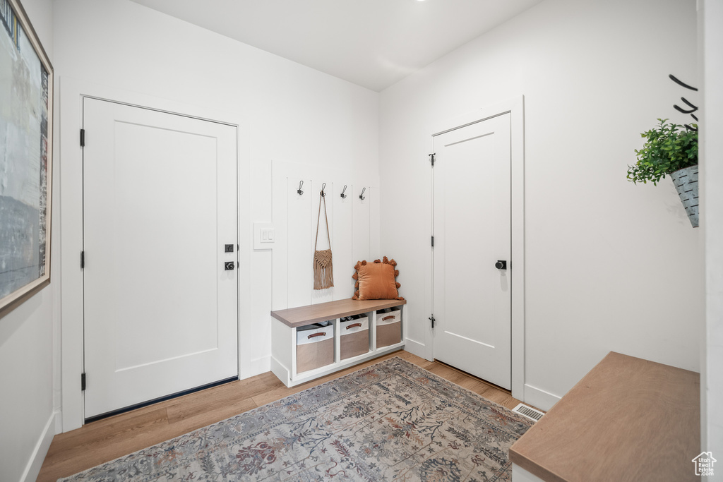 Mudroom featuring light wood-type flooring and baseboards