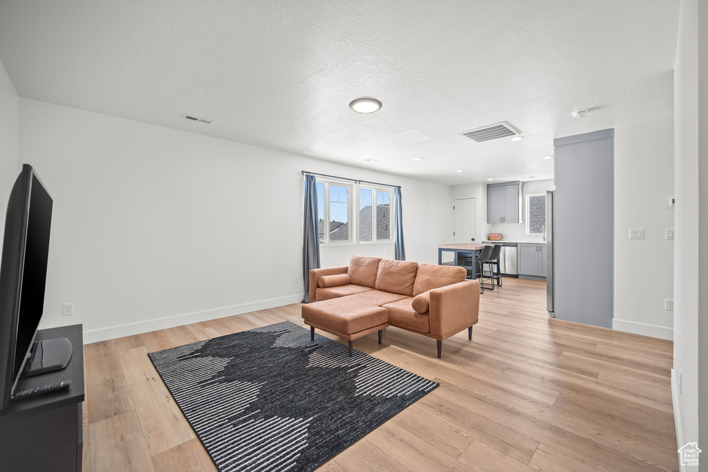 Living area featuring light wood-style floors and a textured ceiling