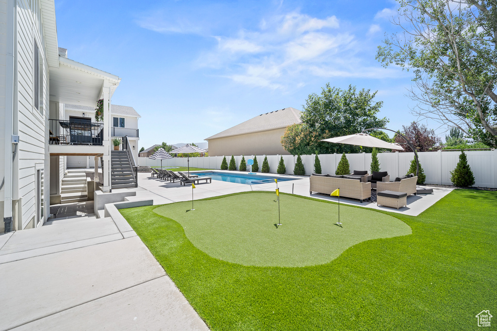 Fenced backyard featuring stairway, an outdoor hangout area, an area to practice putting, and a patio area