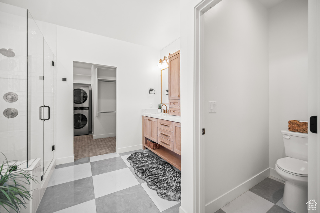 Bathroom with estacked washer and dryer, vanity, and a shower stall