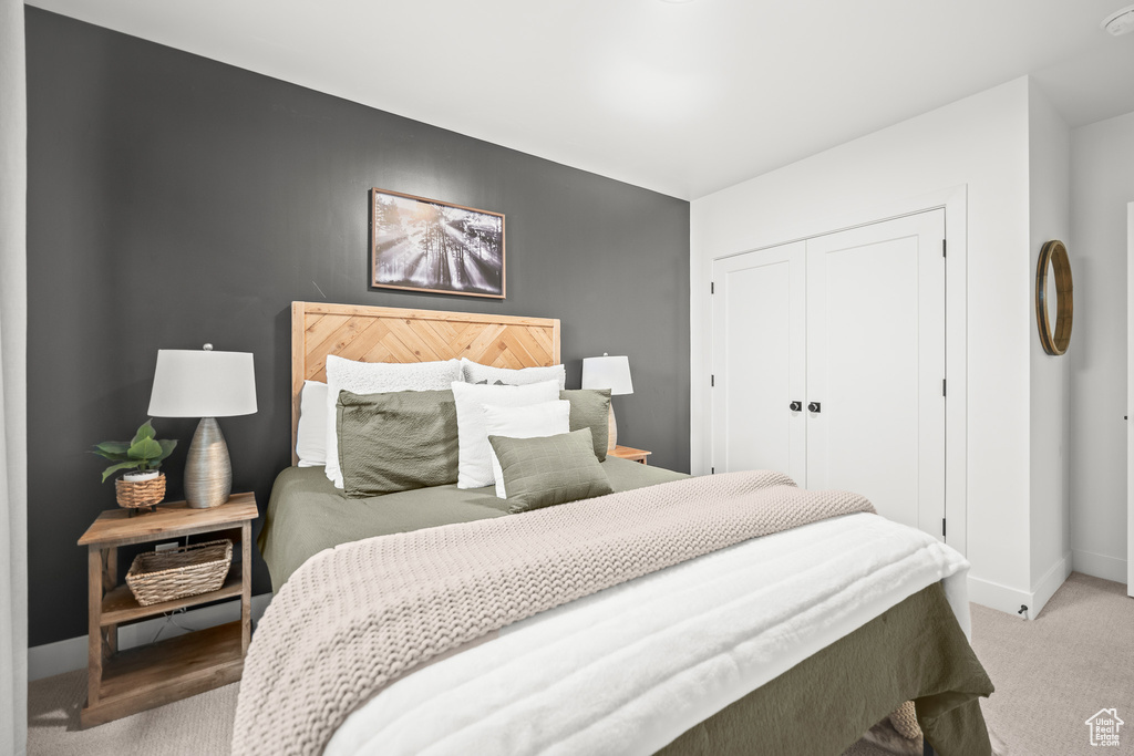 Carpeted bedroom with baseboards and a closet