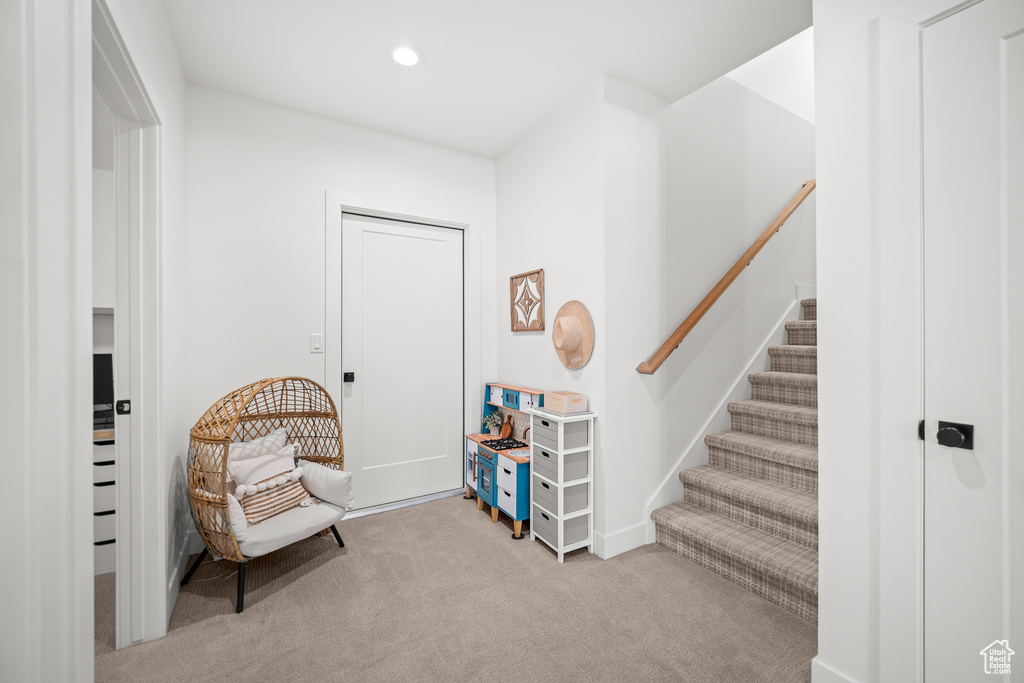 Sitting room featuring carpet floors, recessed lighting, and stairs