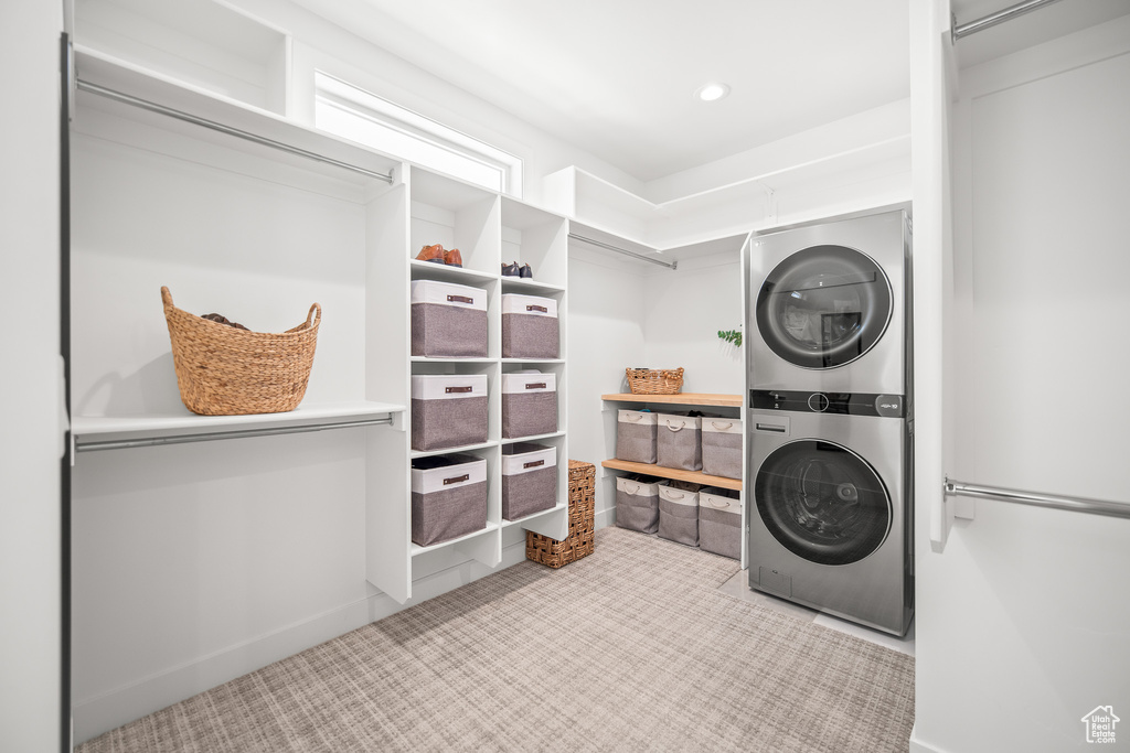 Laundry room with stacked washer and clothes dryer and recessed lighting