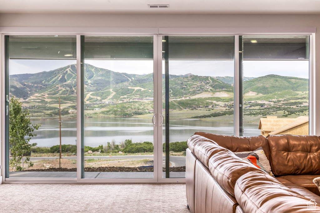 Interior space with healthy amount of natural light and a water and mountain view