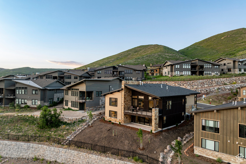 Back of house featuring a mountain view, a residential view, and board and batten siding