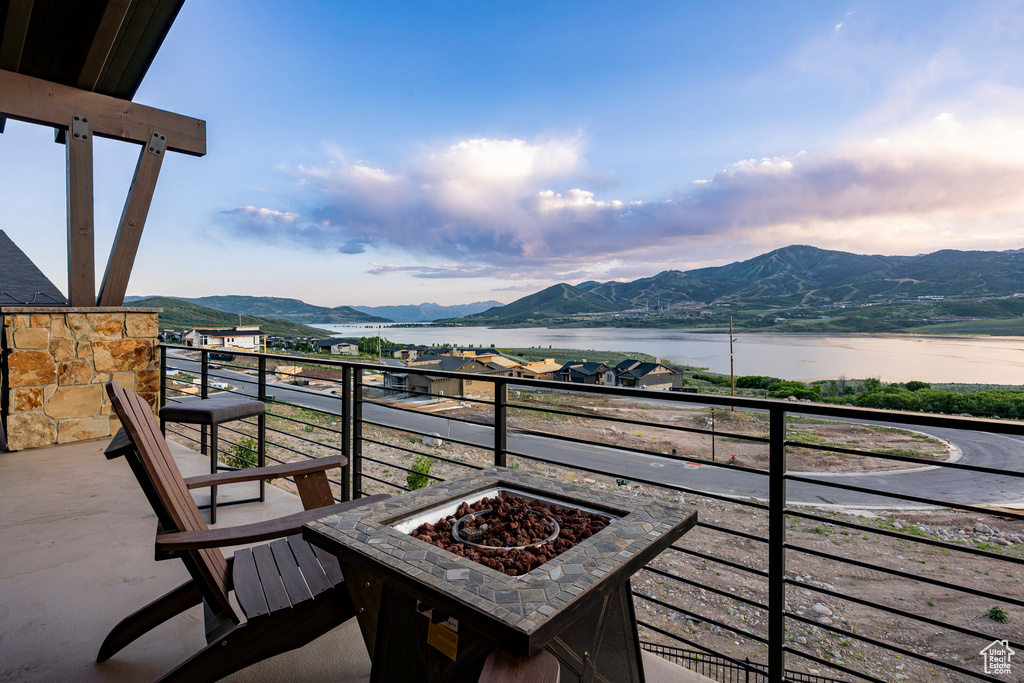 Balcony with a fire pit and a water and mountain view