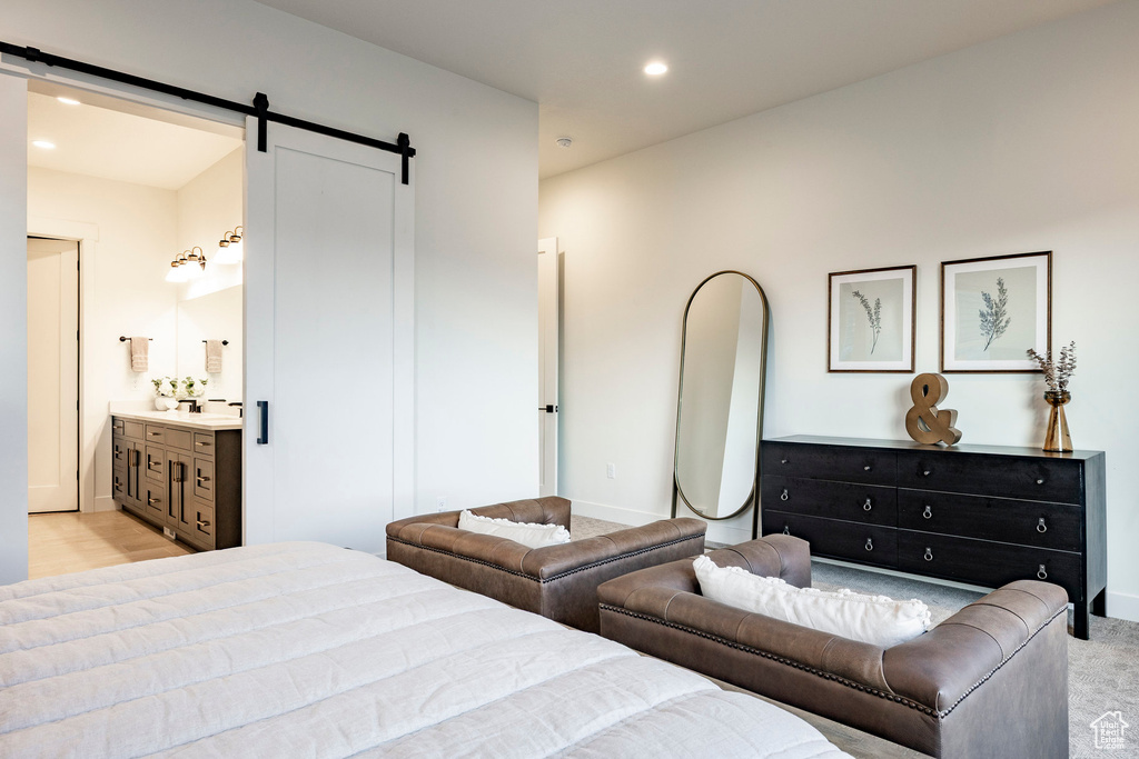 Bedroom with a barn door, recessed lighting, and ensuite bathroom