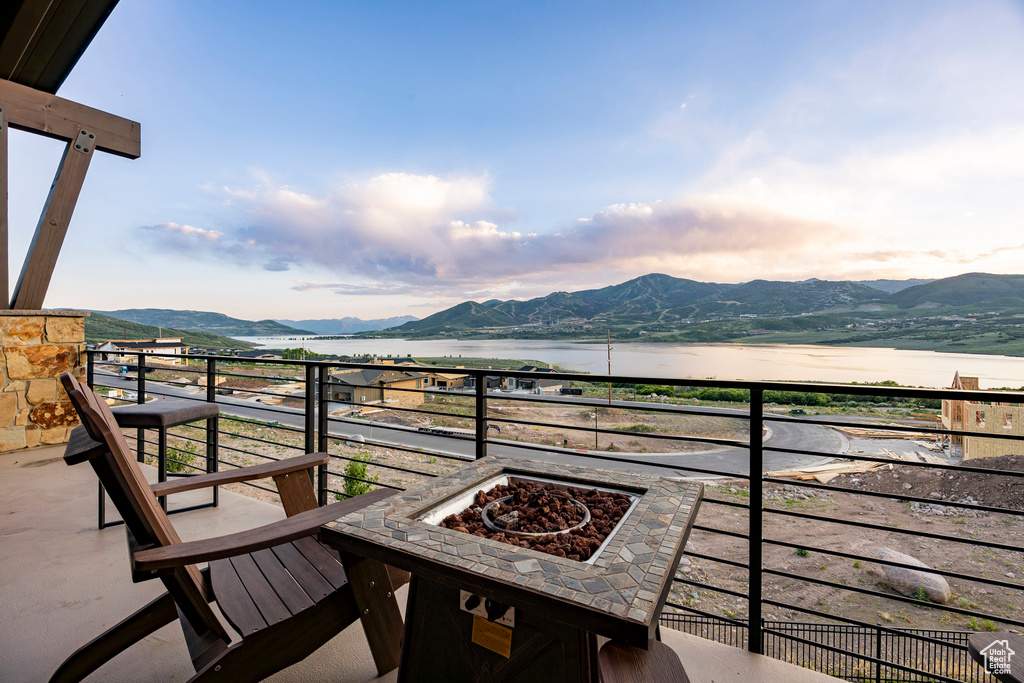 Balcony with a water and mountain view and an outdoor fire pit