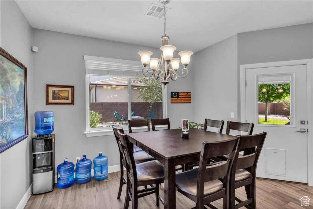Dining area with a chandelier and light wood-style flooring